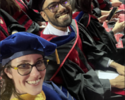 Schloss and Mukherjee seated in regalia at graduation