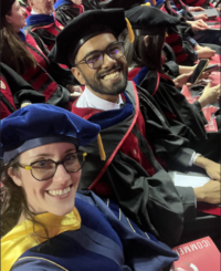 Schloss and Mukherjee seated in regalia at graduation
