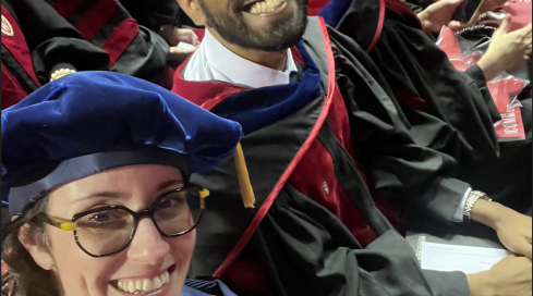 Schloss and Mukherjee seated in regalia at graduation